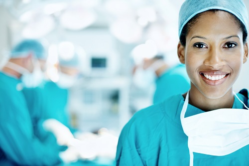 A smiling Lab tech standing in front of surgery not helping at all with her mask down in high risk enviroment.